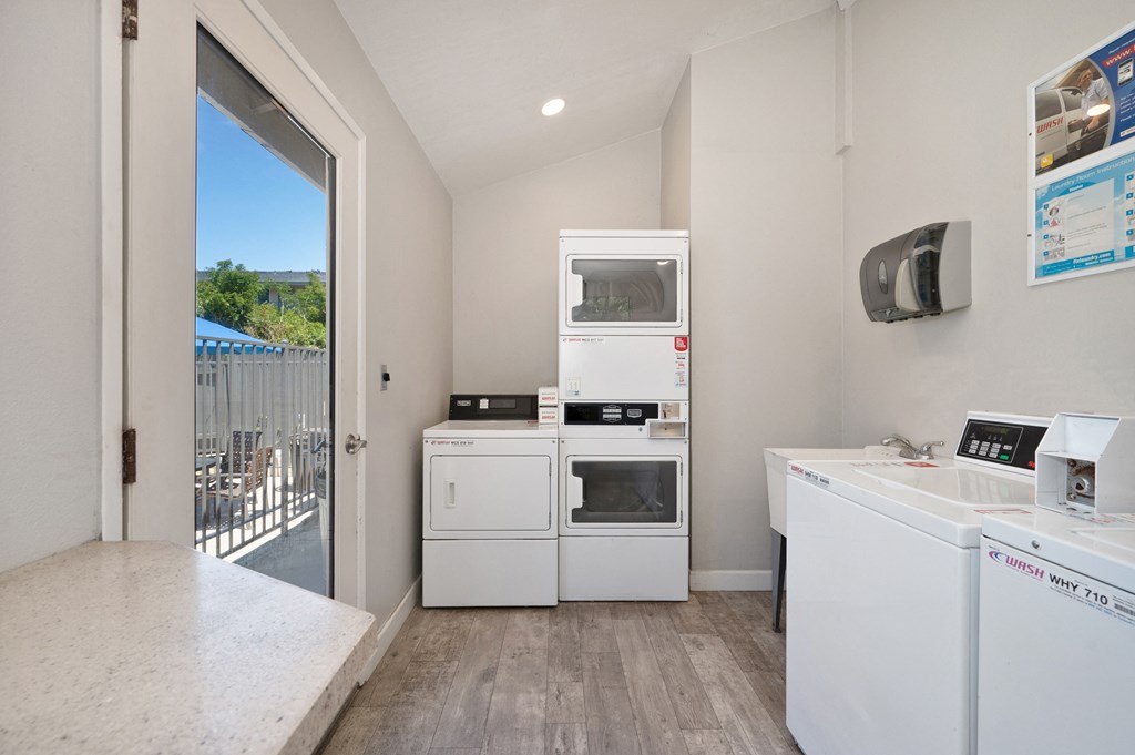 a laundry room with appliances and a door to a balcony