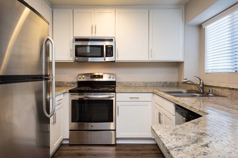 A modern kitchen with stainless steel appliances and white cabinets.