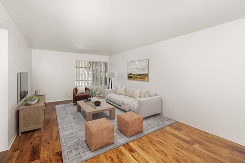 A living room with a grey sofa, wooden coffee table, and a painting on the wall.