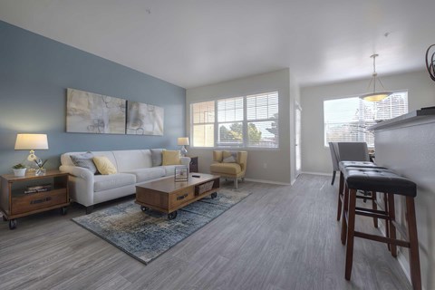 A living room with a white couch, a wooden coffee table, and a rug.