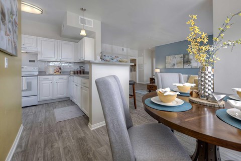 A modern kitchen with a dining table set for two.