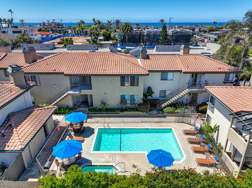 an aerial view of a swimming pool in the backyard of a house
