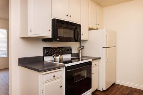 A kitchen with black and white appliances and cabinets.