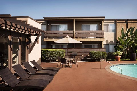 A poolside area with chairs and a table.