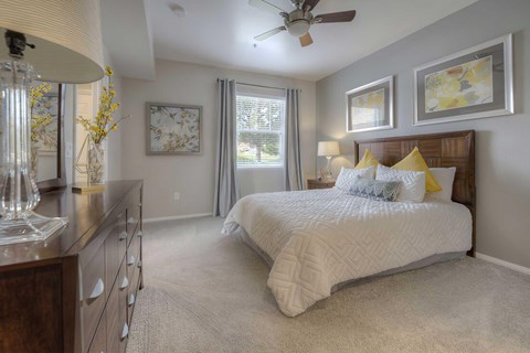 A bedroom with a large bed and a ceiling fan.