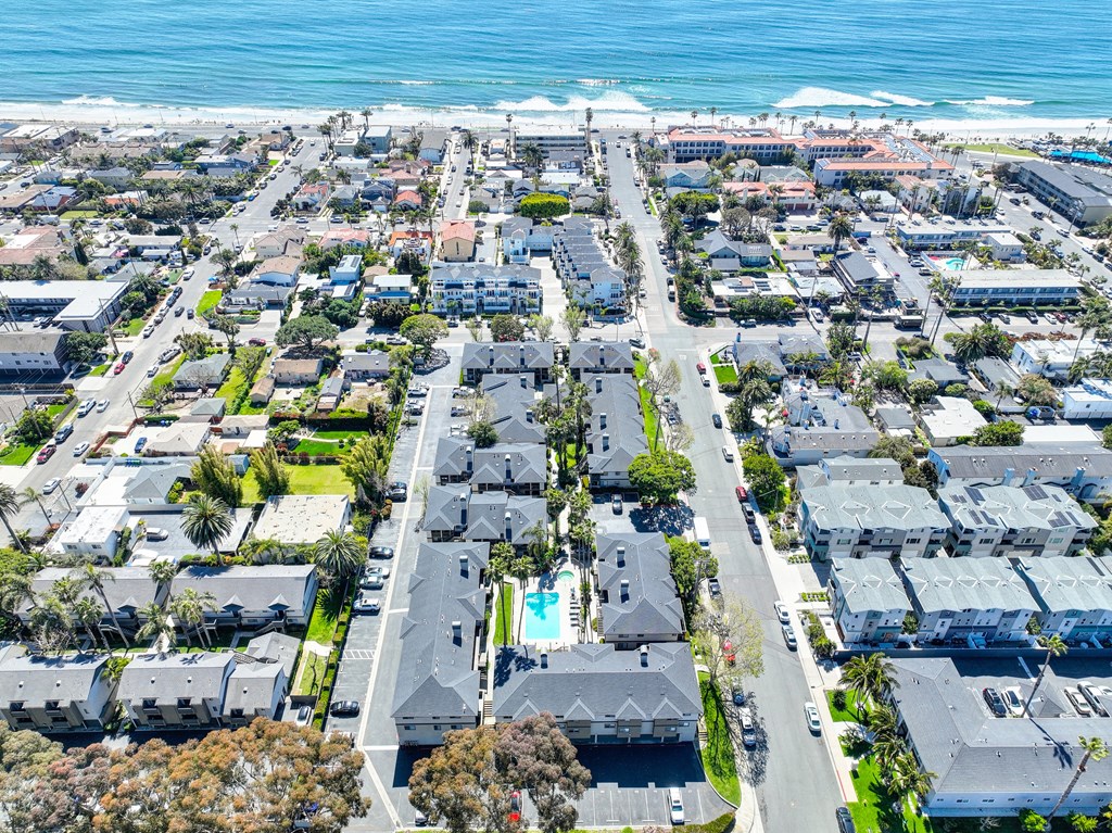 an aerial view of a city with the ocean in the background