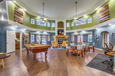 Huge community clubhouse with billiards table, business center, and tables and chairs.