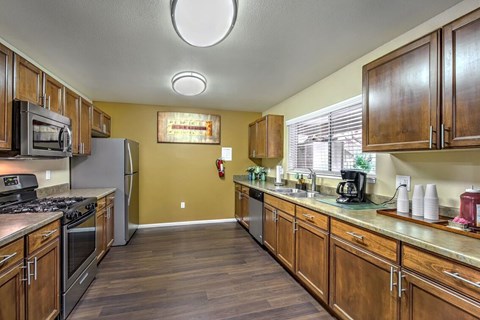 A kitchen with wooden cabinets and a stove top oven.