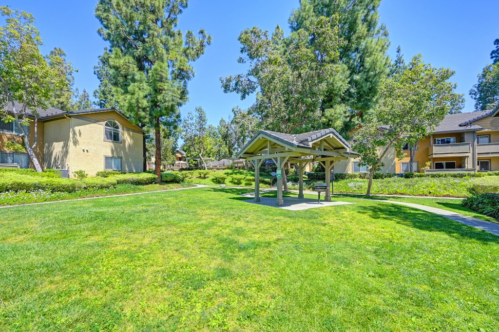 a park with a gazebo in the middle of a yard