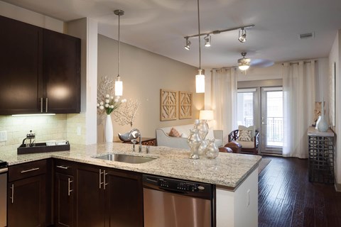 A kitchen with brown cabinets and a granite countertop.