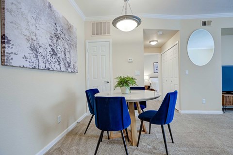 A dining room with a table and chairs.