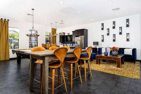 A modern community room with a wooden high table and chairs.