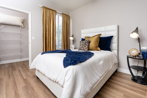 A bedroom with a white bed and a blue throw.