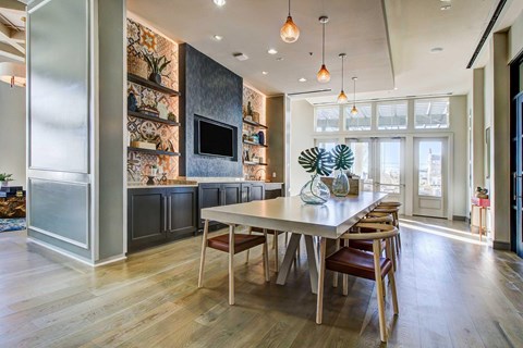 The resident clubhouse with high ceilings, pendant lighting, and plenty of seating,