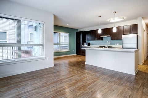 A kitchen with a white counter and wooden floors.