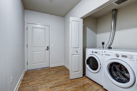 A white door is in a room with a washer and dryer.