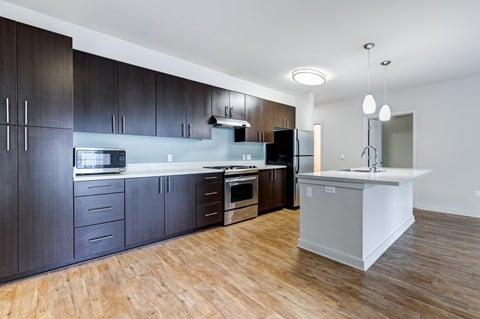 A modern kitchen with dark wood cabinets and a white island.