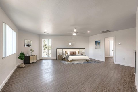 A spacious bedroom with a large bed and a balcony.