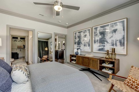 A bedroom with a large bed and a ceiling fan.