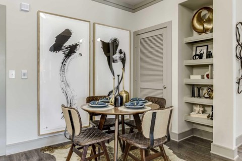 A dining room with a table set for two and two chairs.