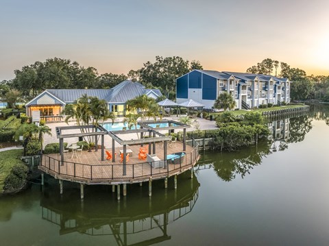 A house with a deck over water and a swimming pool.