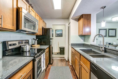 A kitchen with wooden cabinets and granite countertops.