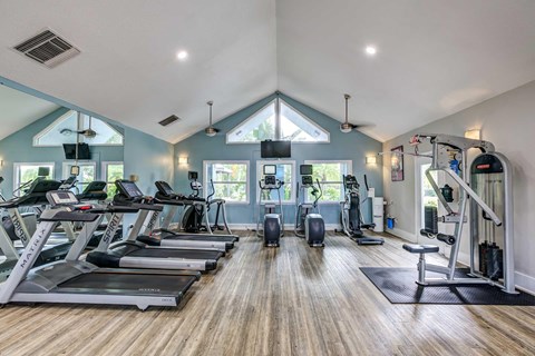 A spacious gym with treadmills, exercise bikes, and other equipment.