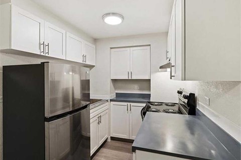 A kitchen with black appliances and white cabinets.