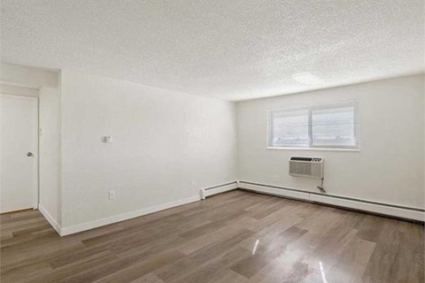 A room with a window and a heater on the wall.
