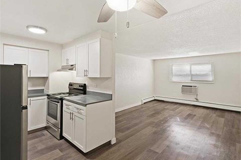 A kitchen with white cabinets and a black countertop.