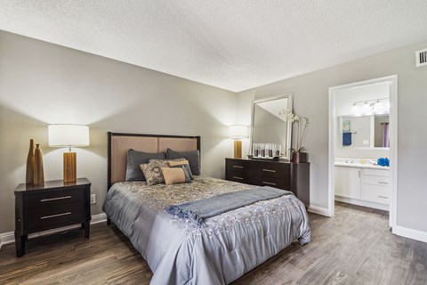 A bedroom with a large bed and a mirror on the wall.