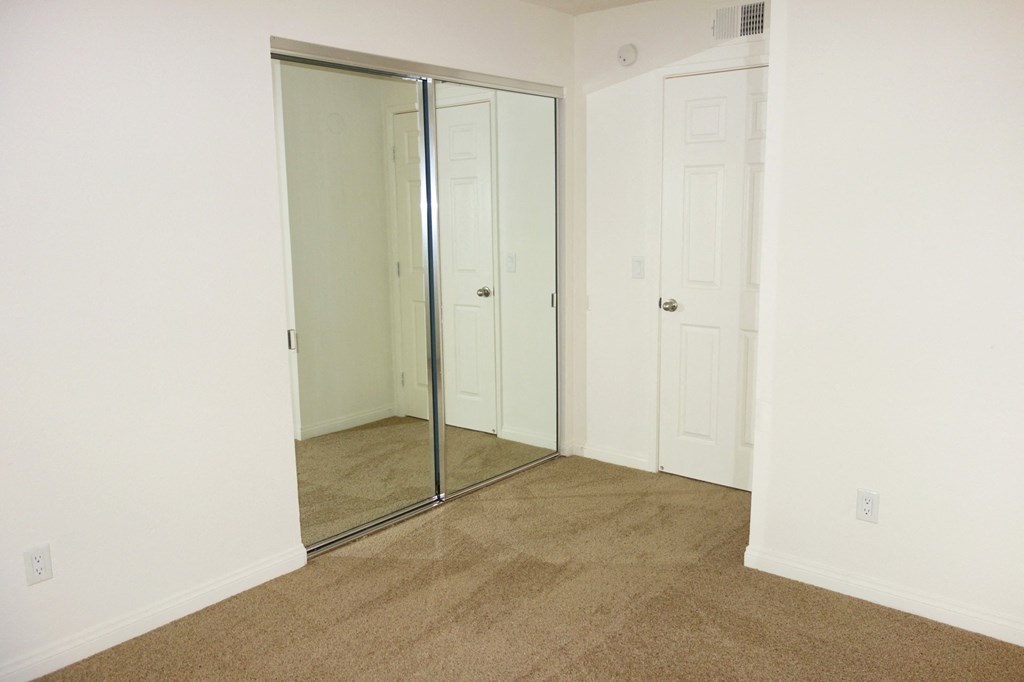a bedroom with white walls and a carpeted floor