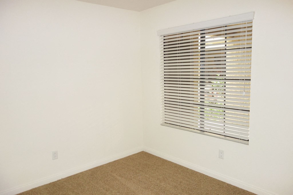 a small room with a window and a cork floor