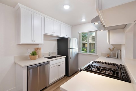 A modern kitchen with white cabinets and stainless steel appliances.