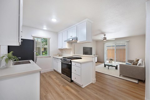 A kitchen with white cabinets and a black refrigerator.