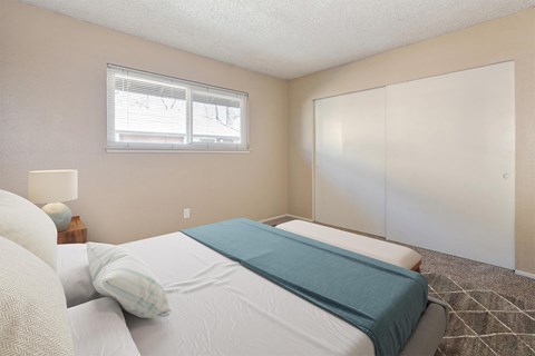 A bedroom with a bed, pillows, and a nightstand.