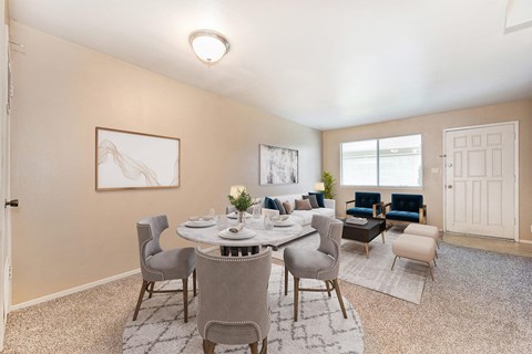A dining room with a round table and grey chairs.