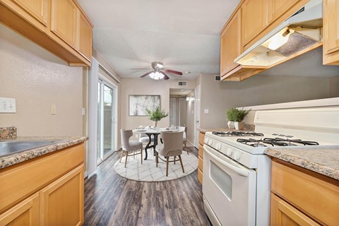 A kitchen with wooden cabinets and a white stove top oven.