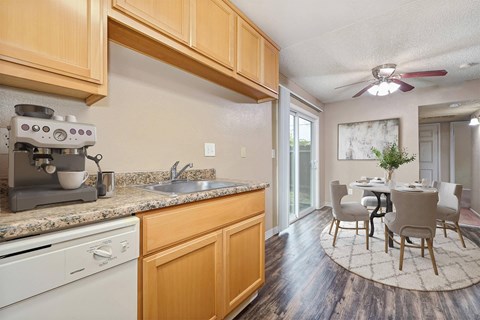 A kitchen with wooden cabinets and a marble backsplash.