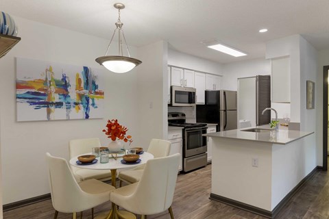 A modern kitchen with a dining table set for four.