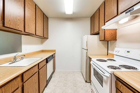 A kitchen with wooden cabinets and white appliances.