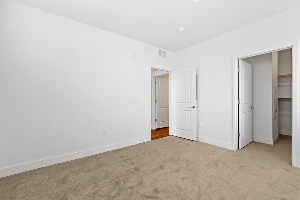a bedroom with white walls and white doors and a carpeted floor