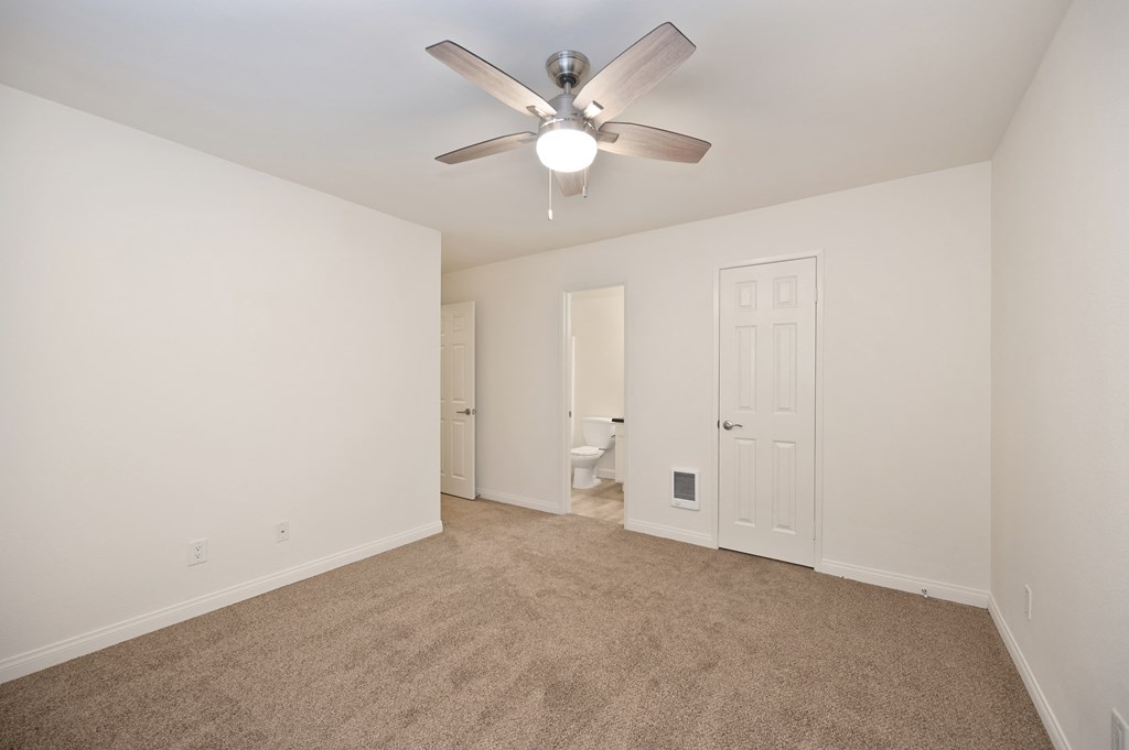 a living room with carpet and a ceiling fan