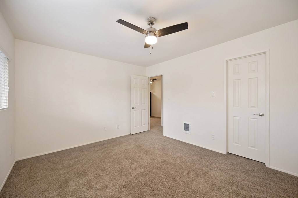 a living room with carpet and a ceiling fan