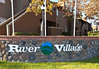 a sign that says river village in front of a house