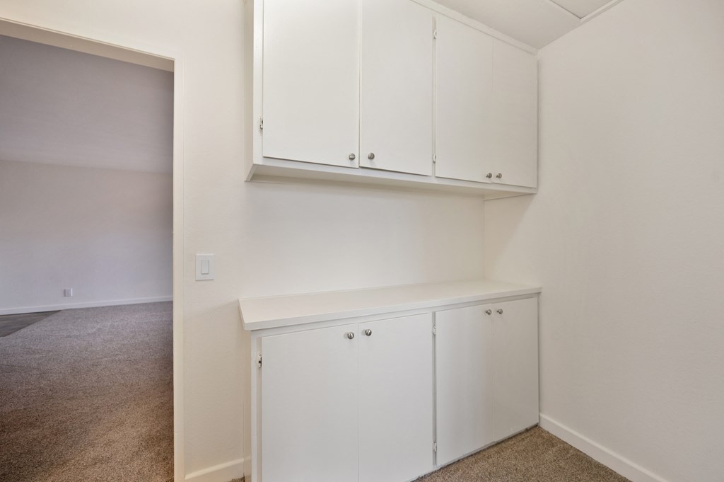 an empty room with white cabinets and white walls