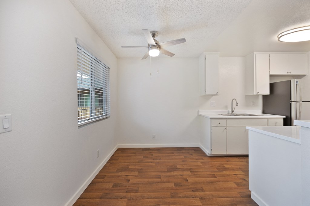 an empty kitchen and living room with a ceiling fan