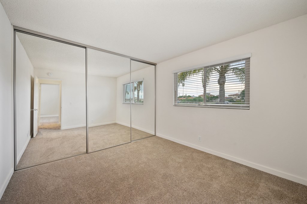 an empty living room with mirrored doors and a window