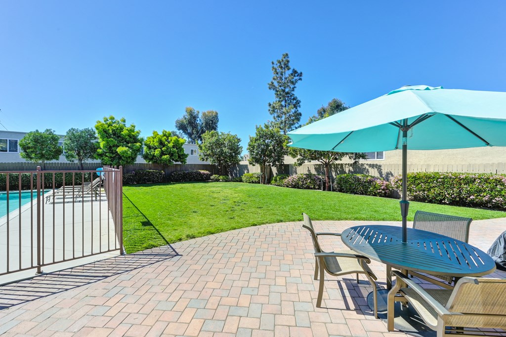 a patio with a table and chairs and a swimming pool
