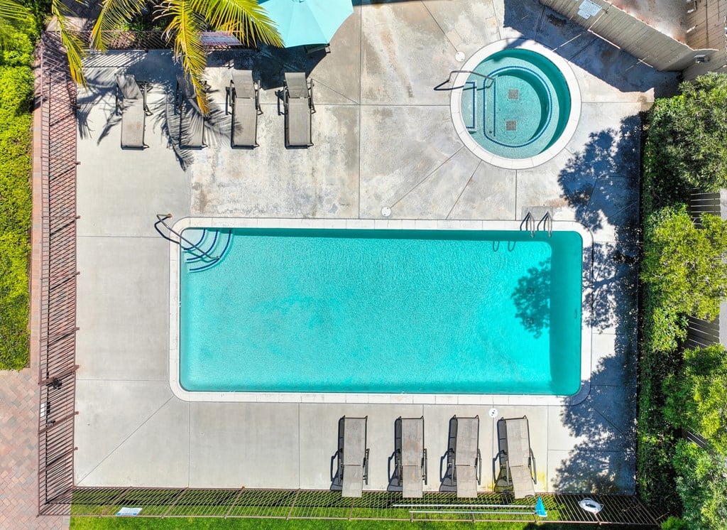 an aerial view of a swimming pool with a pool table and umbrellas